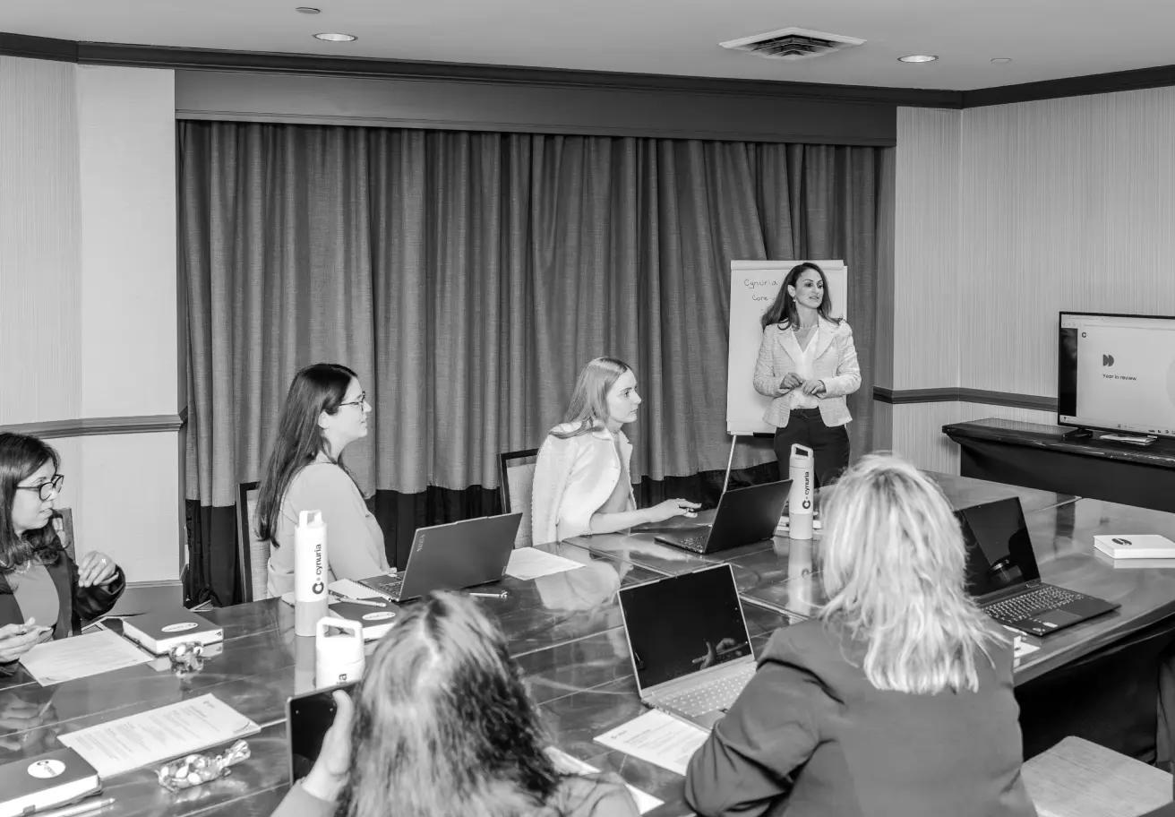 women working around a table with laptops