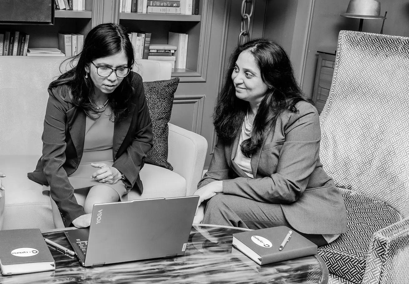three woman discussing work around a computer